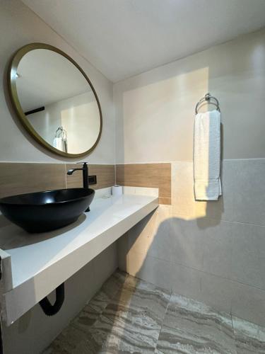a bathroom with a black sink and a mirror at Hotel Coral Boutique in Medellín