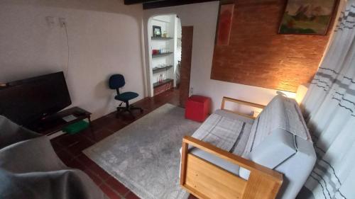 a living room with a couch and a television at CASA DO BRAZ aptos e casa de temporada in Monte Verde