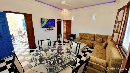 a living room with a glass table and a couch at Villa milka DjerbaSound in Taguermess