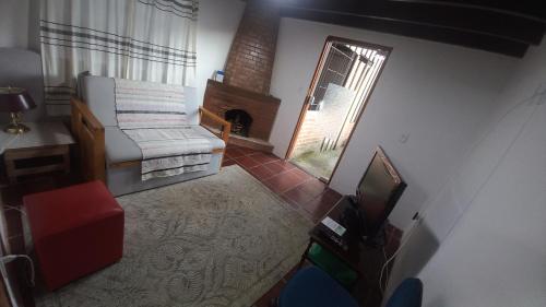 an overhead view of a living room with a television and a fireplace at CASA DO BRAZ aptos e casa de temporada in Monte Verde