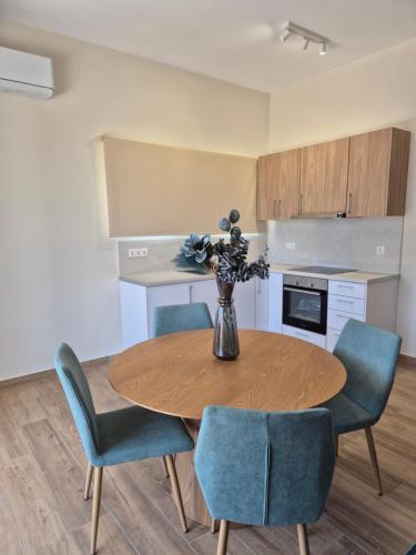 a kitchen with a wooden table and blue chairs at Margarita House in Moraitika