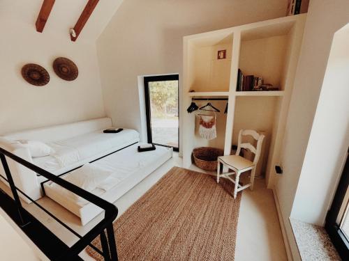 a small room with a bed and a chair at Lusterra Grounds in Amarante
