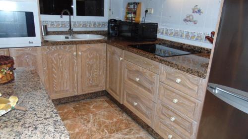 a kitchen with wooden cabinets and a sink at Apartamento 3 dormitorios Almuñécar in Almuñécar