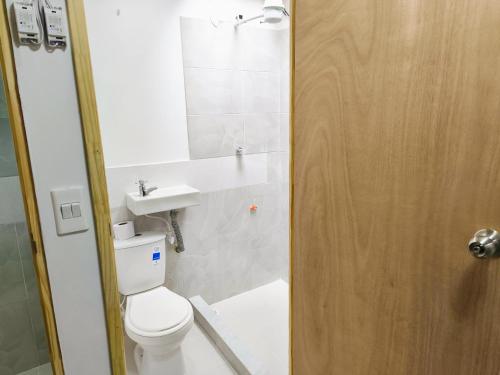 a bathroom with a toilet and a sink at Kuyay Yachi Hostel in Bogotá