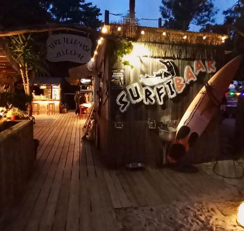 a surf shop with a surfboard on the wall at night at Veela metsamaja in Elbiku