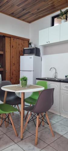 a kitchen with a table and green chairs at Apartamento Adriana in Cartago