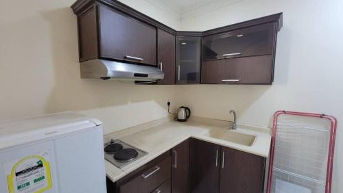 达曼صفاء المسكن的一间设有棕色橱柜和水槽的小厨房