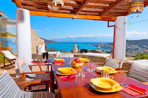 a table with yellow dishes on it on a balcony at Elounda Traditional Homes of Crete in Elounda