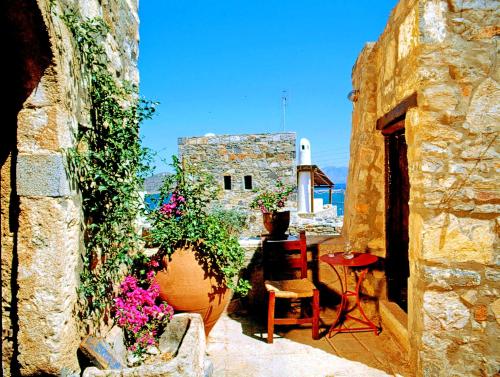 a patio with flowers and a table and a building at Elounda Traditional Homes of Crete in Elounda
