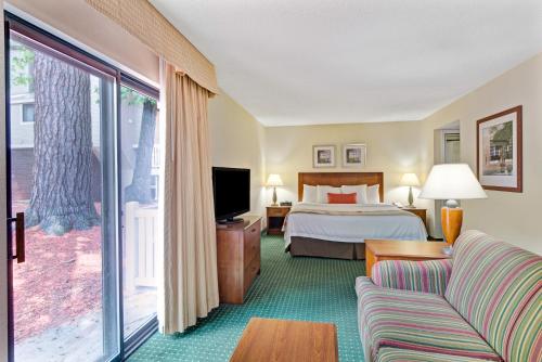 a hotel room with a bed and a tv at Residences at Daniel Webster in Merrimack
