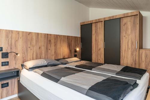 a bedroom with a large bed with wooden walls at Fiore del Brenta 2 a 50 m dalla fermata dello skibus gratuito in Andalo