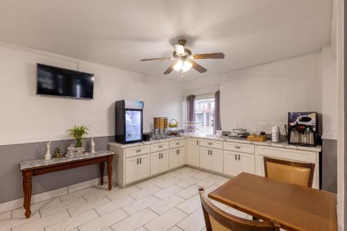 een grote keuken met een tafel en een plafondventilator bij Executive Inn Beeville US 181 in Beeville