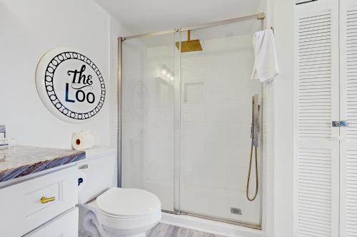 a white bathroom with a shower and a toilet at Seashore Cove in North Topsail Beach