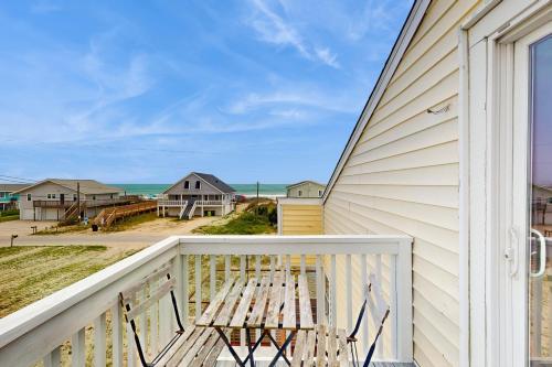a porch with a bench and a view of the ocean at Seashore Cove in North Topsail Beach