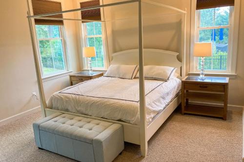a bedroom with a four poster bed and two windows at Grande at Canal Pointe --- 37546 Worcester Dr. in Rehoboth Beach