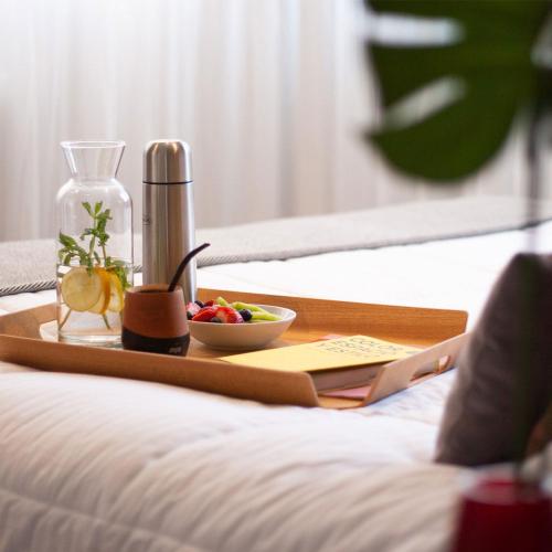 a tray with a bowl of fruit on a bed at Huli B&B in Mendoza