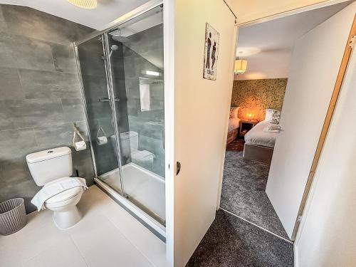 a bathroom with a shower and a toilet at Yellow House Cottage in Southport