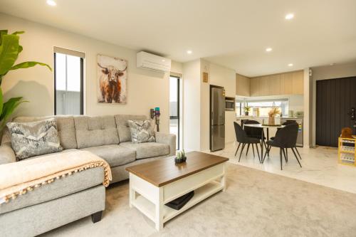 a living room with a couch and a table at Brand New 3BR Home with Parking in Christchurch