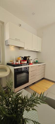 a kitchen with white cabinets and a black oven at A Due Passi dal Mare in Catanzaro