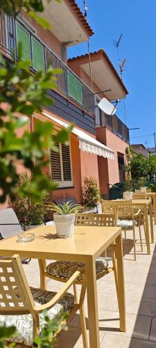 a wooden table and chairs in front of a building at A Due Passi dal Mare in Catanzaro