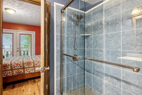 a bathroom with a shower with a glass door at Mountain Chalet with hot tub ! in Gatlinburg