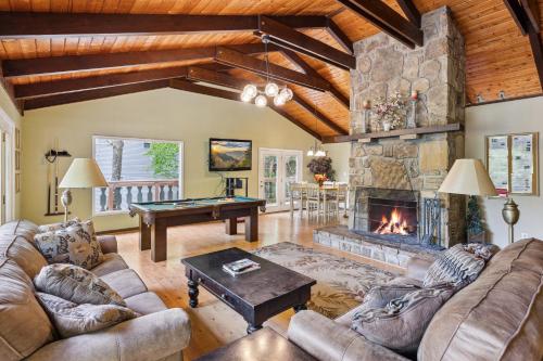 a living room with a stone fireplace and a pool table at Mountain Chalet with hot tub ! in Gatlinburg