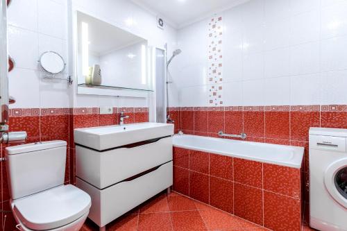 baño rojo y blanco con aseo y lavamanos en Duplex on Main Square, en Leópolis