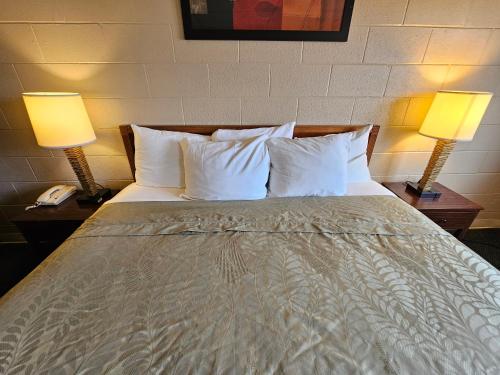 a bedroom with a bed with two lamps and a phone at 1st Choice Inn of Rawlins in Rawlins