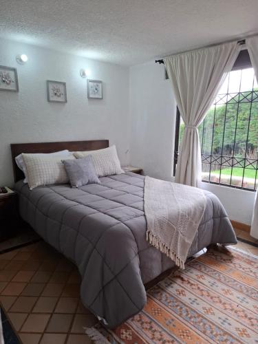 a bedroom with a large bed and a window at House Life in La Calera