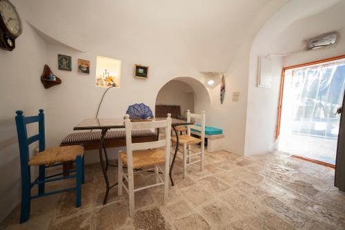 a dining room with a table and chairs and a window at Trullo Degli Ulivi in Ostuni