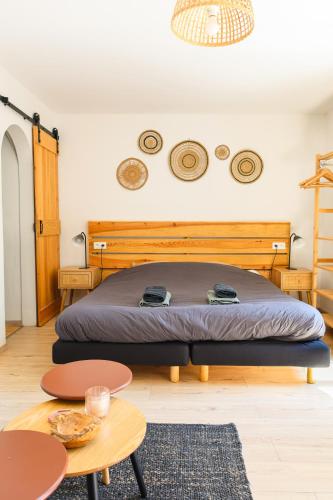 une chambre avec un lit avec une tête de lit en bois dans l'établissement L'Océanaise, à Soulac-sur-Mer