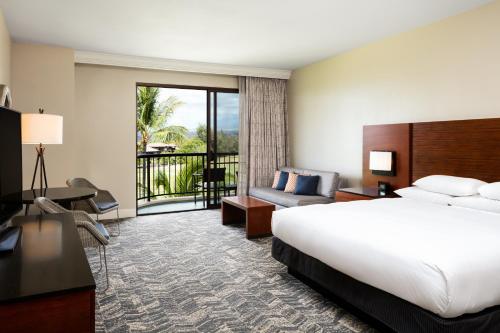 a hotel room with a bed and a balcony at Hilton Waikoloa Village in Waikoloa