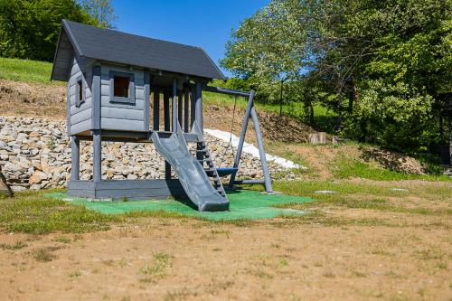 a playground with a slide and a play structure at Antkowe Wzgórze in Polańczyk