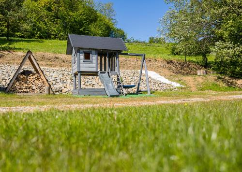 a playground with a slide and a swing at Antkowe Wzgórze in Polańczyk