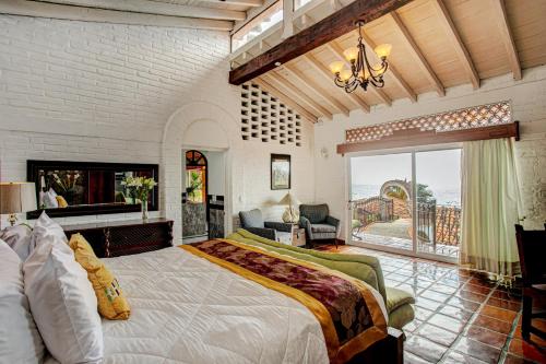 プエルト・バジャルタにあるVilla Celesteの大きなベッドと大きな窓のある寝室
