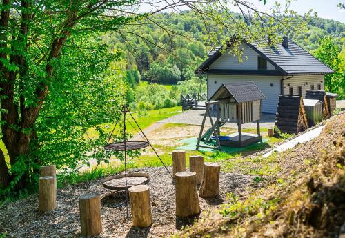 a playground with a swing set and a building at Antkowe Wzgórze in Polańczyk