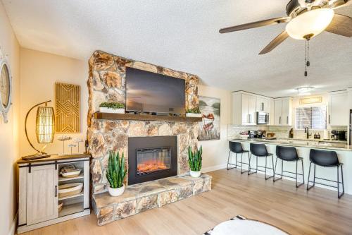 a living room with a fireplace and a kitchen at Lake and Pool Access Lazy Days Condo with Balcony! in Osage Beach