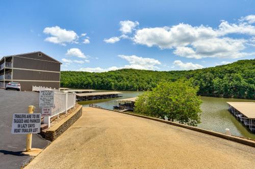 a bridge over a river with a building and a sign at Lake and Pool Access Lazy Days Condo with Balcony! in Osage Beach