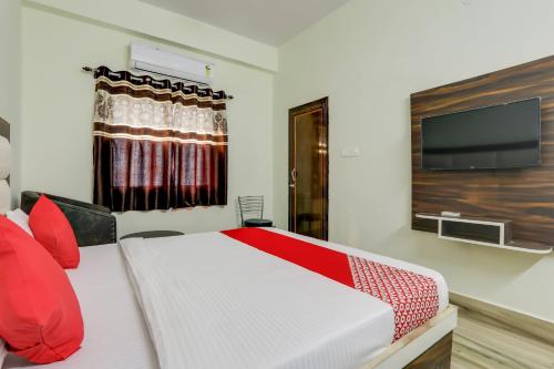 a bedroom with a bed and a flat screen tv at Hotel Navya Grand in Patna