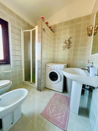 a bathroom with two sinks and a washing machine at Sea&Sage 4 Spiagge Raggiungibili a piedi, Per famiglie con tutti i servizi in Porto San Paolo