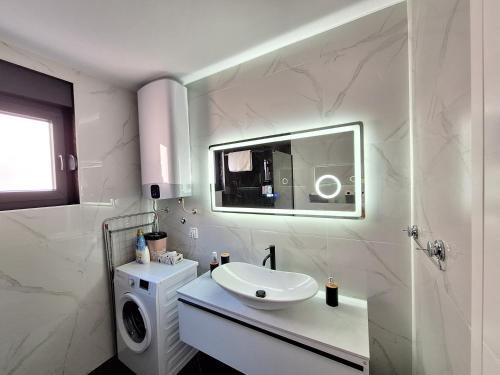 a white bathroom with a sink and a mirror at Apartman IGOR Trebinje in Trebinje