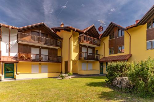 an apartment building with balconies and a yard at Fiore del Brenta 2 a 50 m dalla fermata dello skibus gratuito in Andalo
