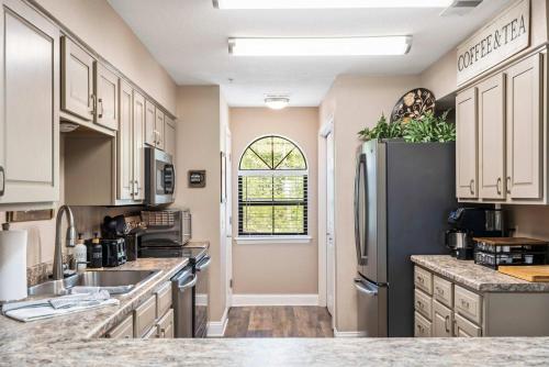 a kitchen with white cabinets and a black refrigerator at Cozy Comfort Retreat - For 6 in Branson