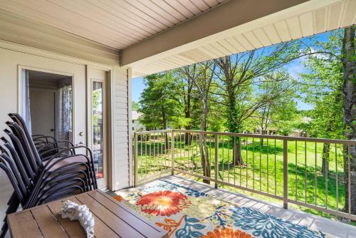 a screened in porch with a table and chairs on a balcony at Cozy Comfort Retreat - For 6 in Branson