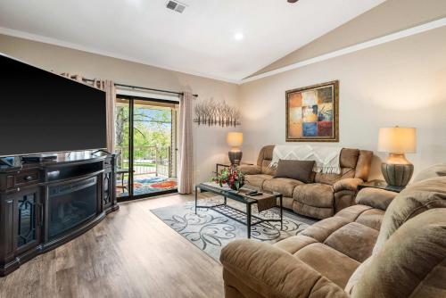 a living room with a large flat screen tv and a couch at Cozy Comfort Retreat - For 6 in Branson