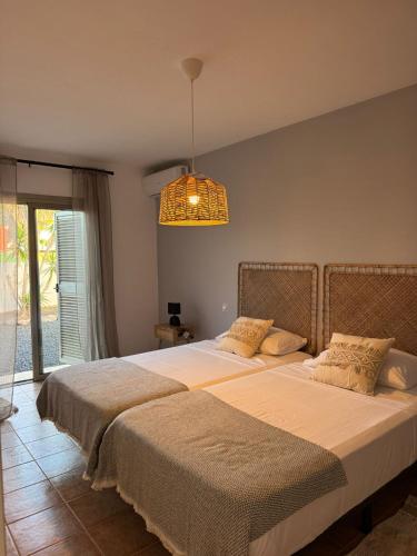 a bedroom with two beds and a chandelier at Villa Atlantic Breeze in Antigua