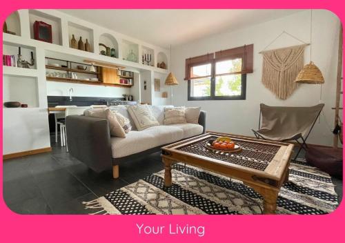 a living room with a couch and a table at Full Relaxation - Private Villa - Sea View - Stunning Garden - 2 Terraces - 2 Bedrooms - Wifi - Parking - Washing Machine in Güime