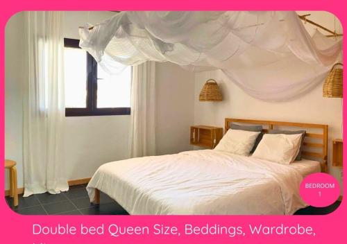 a bedroom with a bed with a white bedspread at Full Relaxation - Private Villa - Sea View - Stunning Garden - 2 Terraces - 2 Bedrooms - Wifi - Parking - Washing Machine in Güime