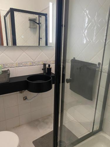 a bathroom with a toilet and a sink and a mirror at Lime Beach 2 in Armação de Pêra