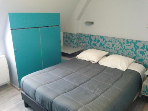 a bedroom with a bed and a blue cabinet at Hôtel de la Grotte in Aix-les-Bains